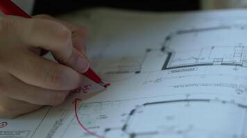 arquitetura Projeto projeto, arquiteto desenhador engenheiro debate e escrevendo vermelho observações em interior desenhando do prédio, chão plano, elaboração impresso em papel. video