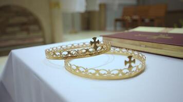 zwei Hochzeit golden Kronen auf das Tabelle im das Kirche. Christian Dekoration Elemente zum das Hochzeit Veranstaltung video