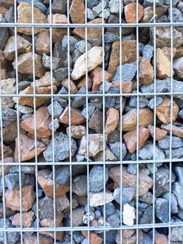close up rocks , A pile of rocks with a metal fence in the background photo