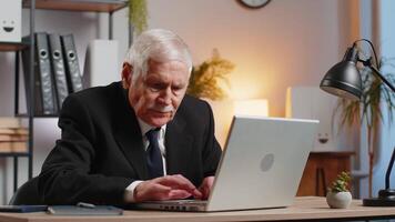 Frustrated businessman having software problems with laptop, angry grandpa gets nervous seeing error or mistake notification at computer screen, mad employee experience virus attack or app malfunction video