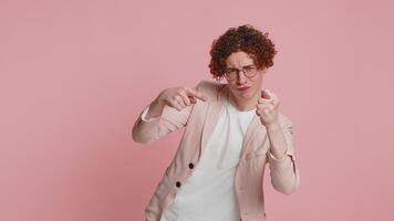 girig girig caucasian lockigt håriga man i jacka som visar fikon negativ gest, du inte skaffa sig den i alla fall. rovgirig, girig förvärvande. kropp språk. vägran fikon tecken. kille på rosa bakgrund video