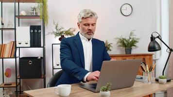 medelålders affärsman på Hem kontor öppnas bärbar dator redo till lyft produktion startande produktiv arbetsflöde. frilansare kille på tabell typer möte arbete tidsfrister spårning framsteg öka produktion dagligen upp. video