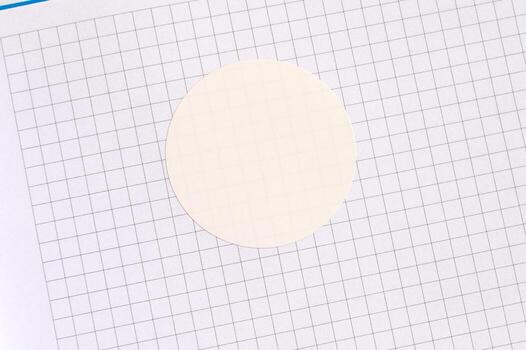 Blank circle sticker on graph paper with gridded background for design and craft use photo