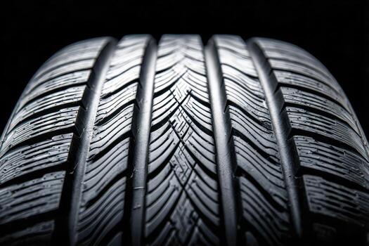Macro view of a wet tire tread showcasing detailed grooves and patterns designed for optimal traction on dark reflective background lighting photo