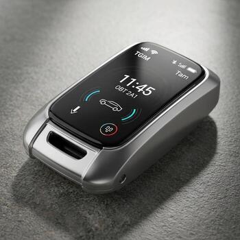 Sleek modern car key fob with a digital touchscreen displaying time and vehicle status on a textured surface photo