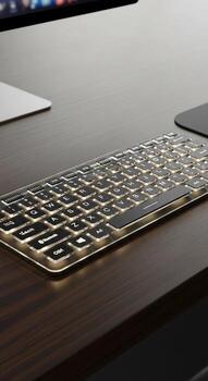 A keyboard on a desk with a computer and mouse photo