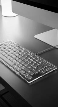A clear keyboard on a desk next to a computer photo
