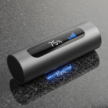 Sleek cylindrical device with a digital display showing 75 battery life reflecting on a textured surface photo