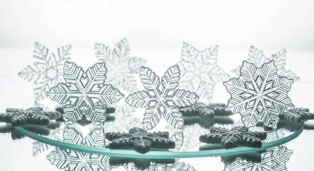 Sparkling frosted snowflake decorations arranged on a reflective surface creating a winter wonderland display photo