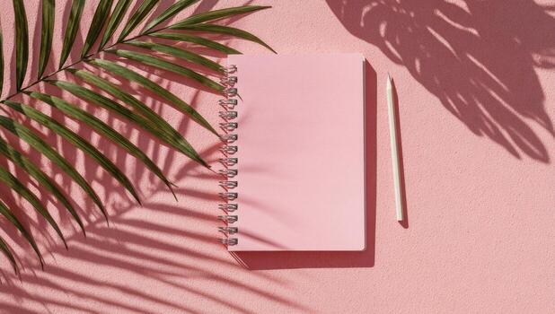Pink notebook with palm leaf shadow photo