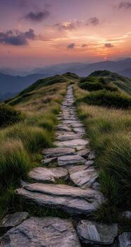 Stone path leading into a sunset over a mountain range photo