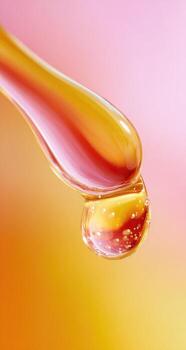 Close-up of a viscous liquid droplet hanging from a dropper photo