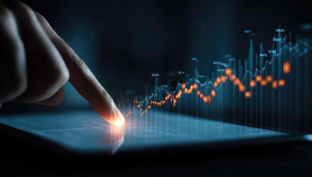 Hand touches a tablet screen displaying financial graphs photo