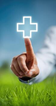 Hand pointing at a glowing plus sign over grass photo