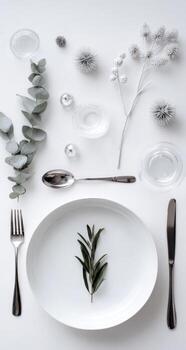 Elegant, minimalist table setting with eucalyptus, sprigs, and delicate accents photo
