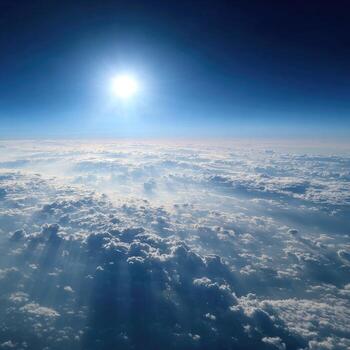High-altitude view of Earth's cloudscape with sunlit clouds and a brilliant blue sky photo