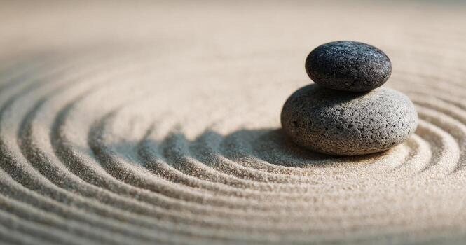 Two stones balanced on sand with concentric circles photo