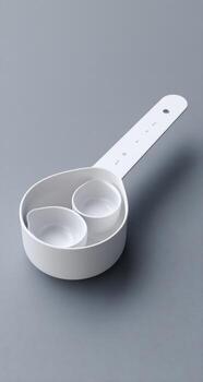 White plastic measuring cup with nested cups and a handle photo