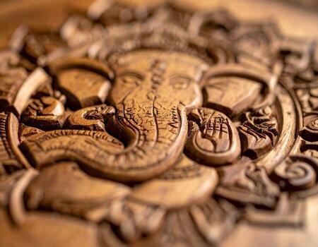 Intricate Wood Carving of Ganesha Detailed Texture and Artistic Craftsmanship. photo