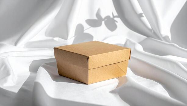 Minimalist Brown Cardboard Box on White Fabric with Leaf Shadow. photo