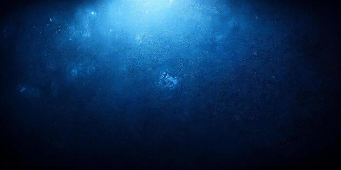 A deep blue textured background features intricate flowing patterns with a bright light illuminating from above photo