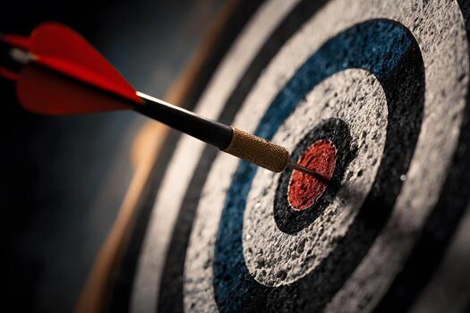 A vibrant red dart is precisely embedded in the central bullseye of a dark round target, representing complete success and accurate aim. photo