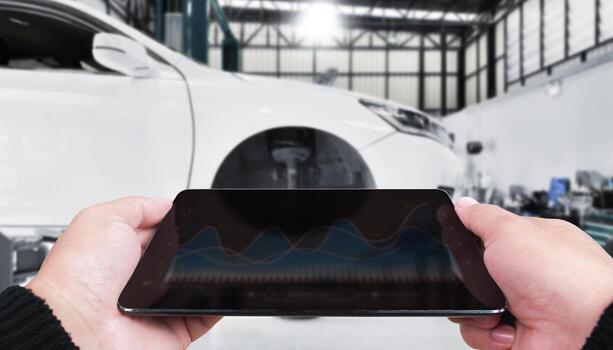 Mechanic using digital tablet with diagnostic graphs in modern auto repair shop, smart technology for car maintenance, vehicle performance monitoring, and predictive service tools photo