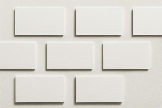 Blank white business cards arranged in grid pattern on neutral background. photo