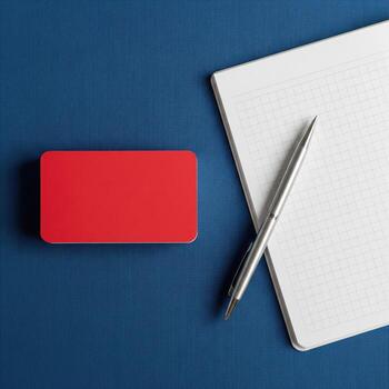Blank Red Business Card Mockup with Pen and Notebook on Blue Background photo