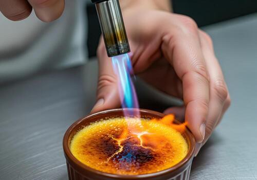 Professional Chef Caramelizing Creme Brulee Sugar with Kitchen Torch photo