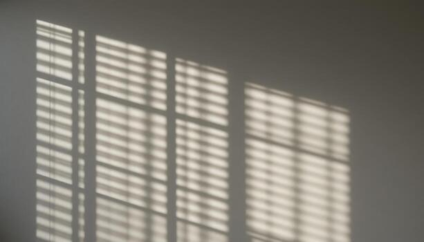 Light Patterns Create Calming Shadows on a Simple Wall From Window Blinds During Daytime photo