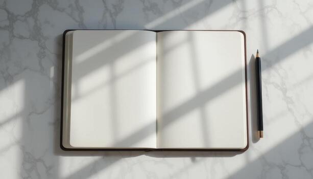 Open Notebook on a Marble Table With Shadows From Nearby Objects Casting Intricate Patterns photo