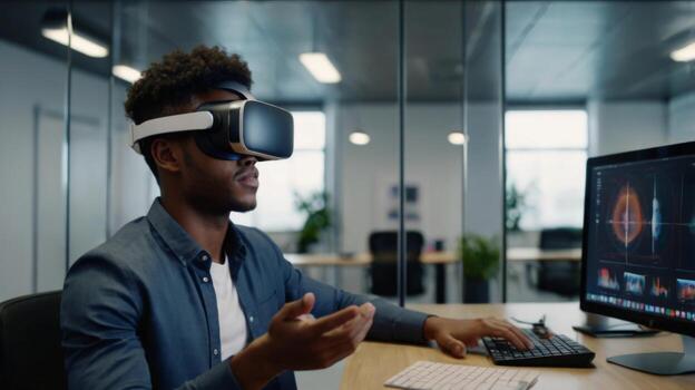 Young man using virtual reality headset in modern office environment with computer displaying sound wave analysis photo