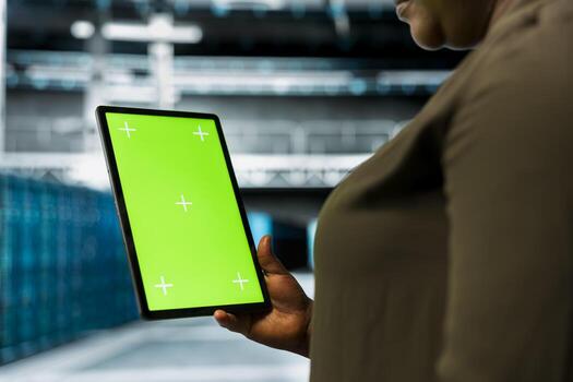 Close up of data center admin using isolated screen tablet to install equipment used for hosting digital services. Server hub worker repairs mainframes managing file transfers using chroma key device photo