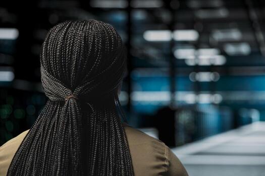 IT specialist walks in high tech data center with rigs supporting business needs. Server room staff member does checkup, ensuring equipment rackmounts work at optimum performance for smooth operations photo