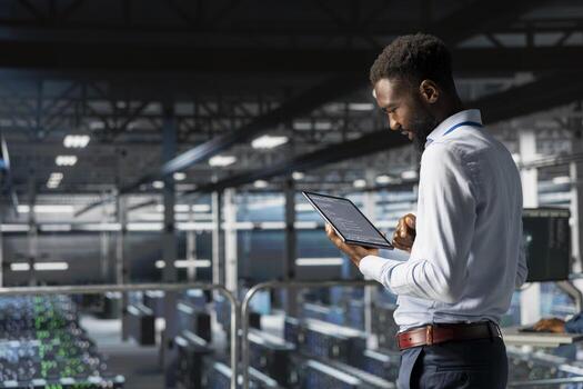 Black data center AI engineer doing maintenance tasks on systems to ensure optimal performance. IT professional reviewing diagnostics to improve stability in server hub, supercomputers. photo