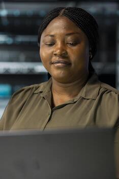 Smiling woman in sustainable high tech data center implementing green technologies. Happy worker coming up with energy efficient solutions to reduce server hub infrastructure carbon footprint photo