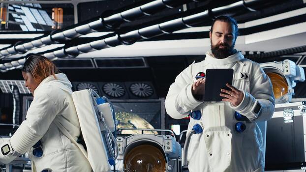 Cosmonaut verifying navigation coordinates on tablet in spaceship during mankind survival expedition. Astronauts calibrating sensors, verifying human expansion in space mission parameters photo