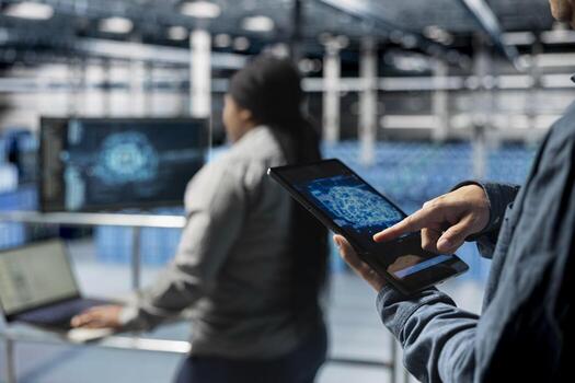Close up of computer scientist in server hub using tablet to enhance AI model accuracy. Data center software developer using device to schedule maintenance for AI hardware rigs photo