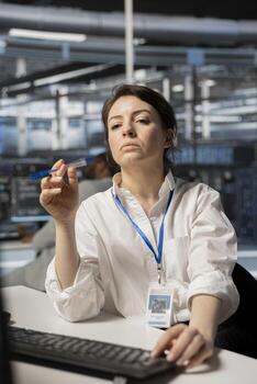 Technician in server room using PC to implement and manage data backup solutions. Data center engineer identifying and resolving technical issues, ensuring efficient recovery photo