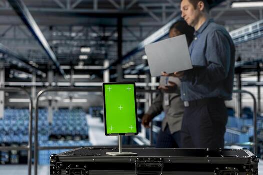 Close up of isolated screen tablet used by teamworking data center admins to reduce downtime. Server hub coworkers monitoring equipment performance using software on mockup device photo