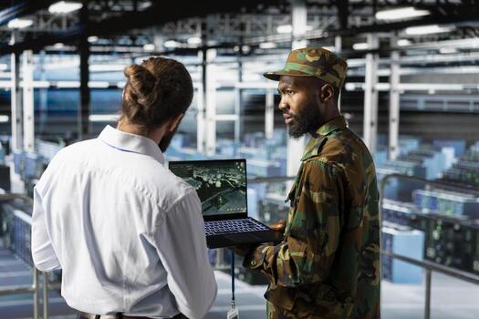 Military operator and IT expert in army data center using AI on laptop to manage autonomous defense systems. Soldier and programmer ensuring strategic threat detection tools for security. photo
