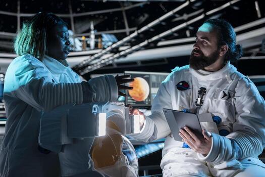 Team of astronauts in starship travelling to Mars conducting safety checks using tablet. Teamworking cosmonauts flying to red planet operating spacecraft control interface, calibrating sensors photo