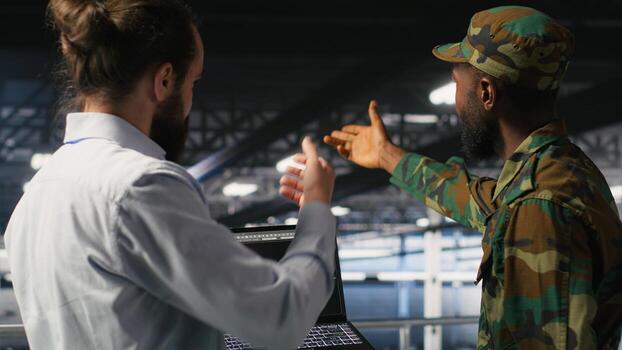 Military personnel overseeing AI computing operations on laptop in high tech server facility. Army tech experts using artificial intelligence to oversee communication systems photo