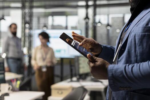 Close up of african american expert uses digital tools for KPI analytics to build a new vision, reviewing performance data insights on tablet for goals achievement in a modern office environment. photo