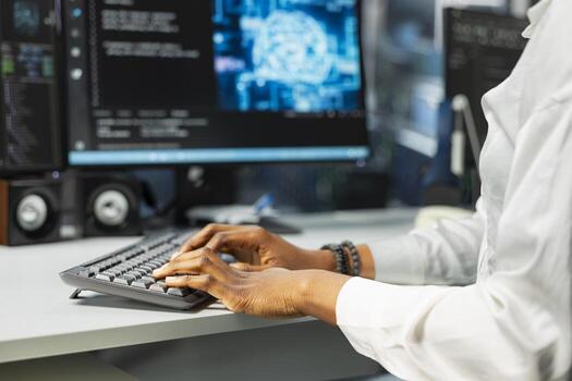 Close up of server farm worker typing on PC keyboard, deploying deep learning tools to automate repetitive workflows. Data center computer scientist managing datasets used in AI training photo