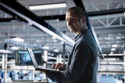 Cheerful server farm worker uses specialized hardware to accelerate complex AI calculations. Portrait of smiling engineer in data center providing computing resources and storage to enable AI training photo