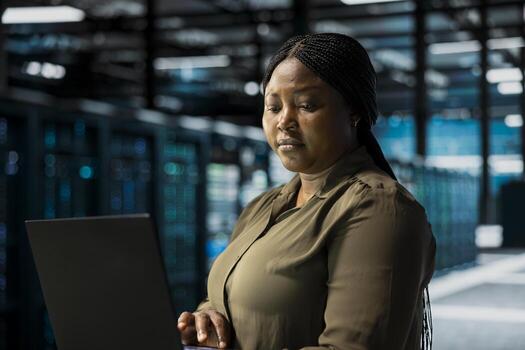 Data center programmer using laptop to optimize network infrastructure, planning capacity. IT expert managing server farm resources with notebook for improved reliability and uptime photo