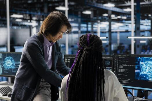 Senior programmer and trainee coding in diverse data center, updating AI automation scripts. Server room manager and intern programming artificial intelligence algorithms photo