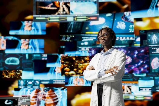 Portrait of healthcare specialist reviewing CT scans, MRI data, and lab analytics displayed on videowall. Scientist in medical research lab visualizing health data on futuristic panels photo